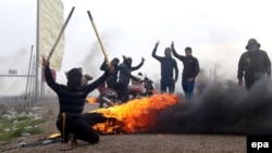 Iraqi Sunni fighters burn tires to close the road as Iraqi security forces launch a military operation in the western province of Anbar on December 30. 