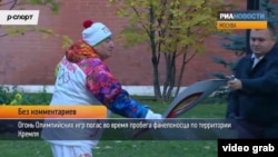 Russian Olympic torchbearer Shavarsh Karapetyan gets help relighting the torch after it flickered out at the Kremlin in Moscow on October 6.