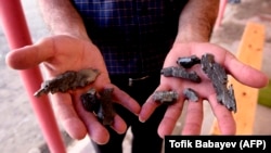 A man shows artillery shell fragments in the village of Agdam in the Tovuz district near the Azerbaijani-Armenian border in July.