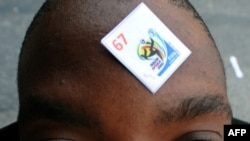 A soccer fan sports his number on his forehead as he waits in line outside a FIFA ticketing office in Johannesburg.