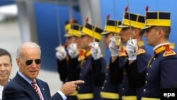 U.S. Vice President Joe Biden (light) inspects a guard of honor upon arriving