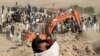 An excavator removes mud from a collapsed house amid the search for victims after an earthquake in the Zindah Jan district of Herat Province in western Afghanistan. 