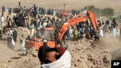 An excavator removes mud from a collapsed house amid the search for victims after an earthquake in the Zindah Jan district of Herat Province in western Afghanistan. 