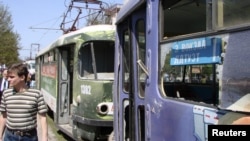 A man walks past damaged trams at the scene of one of the explosions in Dnipropetrovsk.