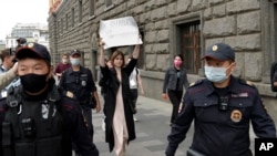 Russian police detain a protester holding a placard that says "Journalism is not a crime." (file photo)