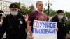 Russian police detain an opposition activist who is holding a poster reading "Smart Voting" in Moscow on August 14.