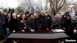 Relatives and other mourners gathered around the coffin at the funeral in Volgograd on December 31 to bury the first of the dozens killed on December 29 and 30.