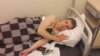 Aleksandr Turovsky lying in a hospital bed after being beaten by police