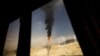 A gas flame is seen through a bus window at the South Pars gas field facilities in Iran's southern port of Assaluyeh.