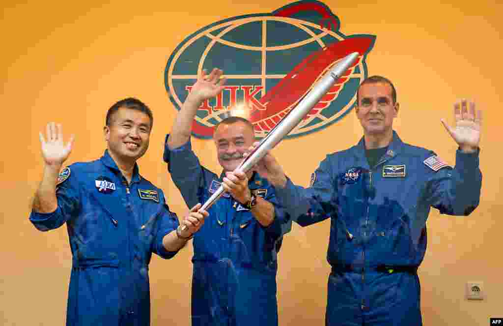 This photo from Kazakhstan shows (left to right) Soyuz Flight Engineer Koichi Wakata from Japan, Commander Mikhail Tyurin from Russia, and Flight Engineer Rick Mastracchio (from the U.S.) holding the Olympic torch prior to boarding the Soyuz TMA-11M rocket on November 7, 2013.