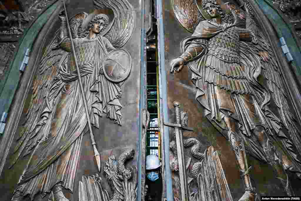 A worker pushes open an entrance to the cathedral on April 27.&nbsp;