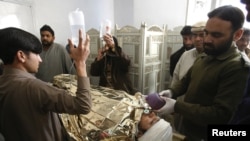 An antipolio campaign worker, Hilal Khan, who was shot and badly injured by unidentified gunmen, receives treatment at Lady Reading Hospital in Peshawar on December 19.