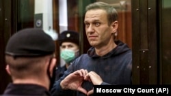 Russian opposition leader Aleksei Navalny shows a heart symbol during a court hearing in Moscow on February 2.