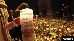 A woman holds a candle amid a sea of flowers and lit candles placed in memory of those killed in the July 22 bomb and shooting attack in front of Oslo Cathedral on July 25.