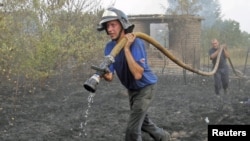 Firefighters work to extinguish fire at a house in Berestyanki in the Ryazan region 