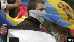 Moldovan students hold a sign saying "Europe Help Us" protest in front of the government building in Chisinau on April 10.