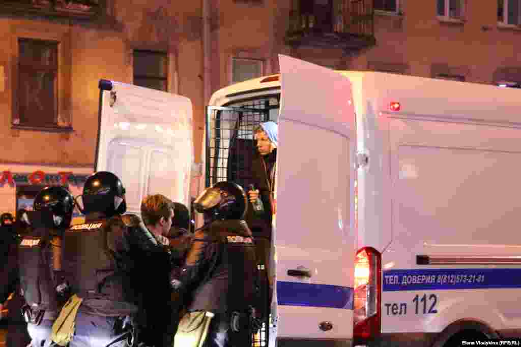 St. Petersburg security forces load detainees into a police van. More than 10,000 people across Russia have been detained at protests in support of Navalny since January.