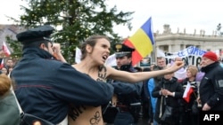 Police try to stop an activist of the Ukrainian feminist group Femen from protesting on St. Peter's Square at the Vatican on January 13.