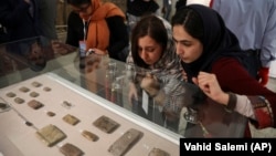 Journalists look at ancient clay tablets that were returned to Iran from the United States at the National Museum in Tehran in 2019.