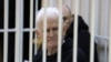 Nobel Peace Prize laureate Ales Byalyatski, who co-founded the Vyasna human rights group, sits inside a defendants' cage during a court hearing in Minsk in January 2023.