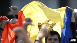 Protesters wave the Moldovan flag near the government building in Chisinau on April 8