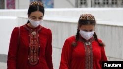 Women wearing protective face masks walk along the street in the Turkmen capital, Ashgabat. (file photo)