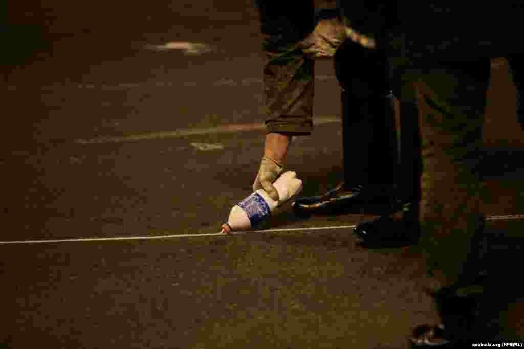 A soldier draws a line on the asphalt for parade coordination.