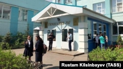 Students stand outside School No. 7 after a teenager brought a pistol and a knife to his school and allegedly held his classmates hostage, in Kazan on May 13.