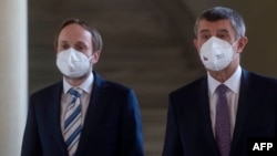 The Czech Republic's newly appointed Foreign Minister Jakub Kulhanek (left) and Czech Prime Minister Andrej Babis speak to journalists in Prague on April 21. 