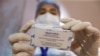 A medical worker holds a box containing vials of the QazCovid-in vaccine -- commonly known as QazVac -- in a vaccination center in Almaty.