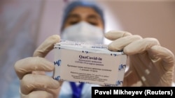 A medical worker holds a box containing vials of the QazCovid-in vaccine -- commonly known as QazVac -- in a vaccination center in Almaty.