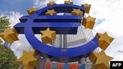 A giant logo of the euro currency stands in front of the European Central Bank in the banking district of Frankfurt, Germany.