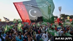 Activists from the Pakistan Democratic Movement (PDM), an opposition alliance of 11 parties, wave party flags during the alliance's first public rally in the eastern city of Gujranwala on October 16.