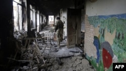 A Ukrainian serviceman walks through a destroyed school in the village of Pisky near Donetsk late last year.