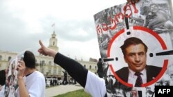 Members of a Georgian political youth group hold portraits of President Mikheil Saakashvili demanding answers about the 2008 Russia-Georgia conflict at a rally in Tbilisi in April 2009.