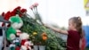 A young girl lays flowers at an impromptu shrine to victims of a deadly school shooting that took place in Tatarstan's capital, Kazan, earlier this week. 