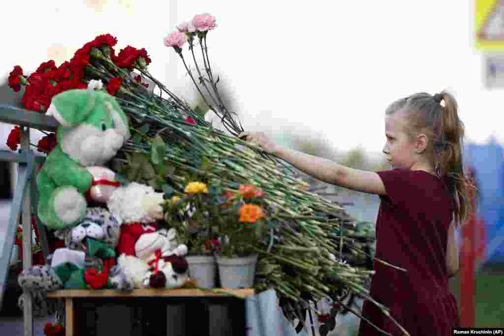 A girl lays flowers near a school after the shooting in Kazan on May 11.