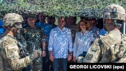 Macedonian Prime Minister Zoran Zaev (C) and Defense Minister Radmila Secerinska (R) meet with U.S. troops during a joint military exercise 