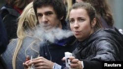 Russian students smoke on a street in Moscow