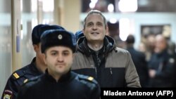 Dennis Christensen is escorted into the courtroom to hear his verdict in the town of Oryol on February 6.