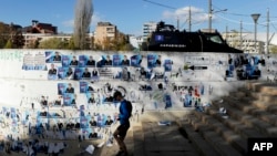 A man walks in front of a wall covered by electoral posters in the divided town of Mitrovica on November 4.