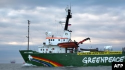 Greenpeace's icebreaker "Arctic Sunrise" sails the Pechora Sea somewhere off Russia's northeastern coast with Gazprom’s "Prirazlomnaya" Arctic oil platform in the background in a Greenpeace handout photo from September 17.