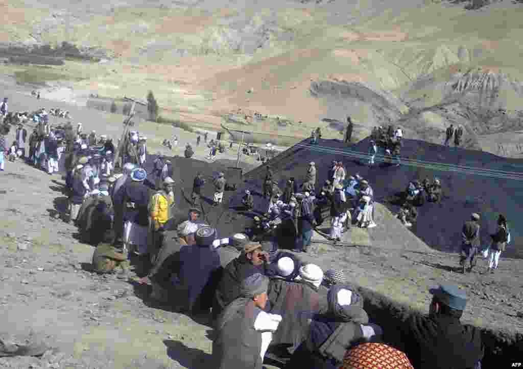 Miners sit at the entrance the collapsed mine on September 15, 2013.