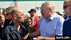 Belarusian President Alyaksandr Lukashenka (right) argues with a MZKT worker at the plant in Minsk on August 17.