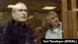 Mikhail Khodorkovsky (left) and co-defendant Platon Lebedev stand behind a glass wall in court in Moscow in May 2011.