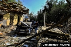 Residents search for their belongings at a restaurant hit by shelling in the town of Bardain on October 8 in Nagorno-Karabakh.