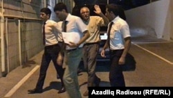 Mehman Aliyev (center), the director of independent Azerbaijani news agency Turan, is taken to detention.