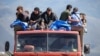 Refugees from Nagorno-Karabakh ride on a truck arriving at the border village of Kornidzor, Armenia, on September 27.