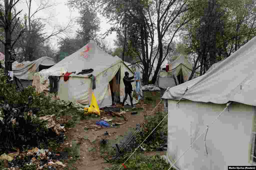 A migrant cleans his bedding among tents at the Vucjak camp. Since 2018, the EU has paid Bosnia 34 million euros ($37.4 million) to help manage the country&rsquo;s migrant situation. &nbsp;