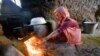 A girl lights a cooking fire in Tajikistan's Khatlon region.